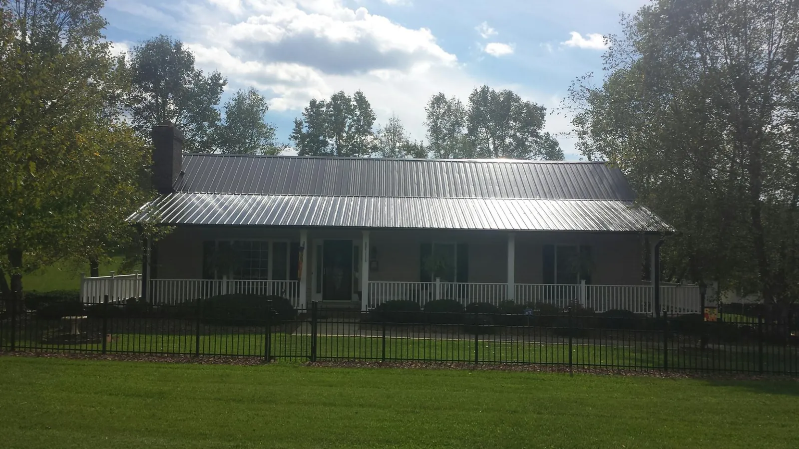 Gray metal roof on a brick ranch with a full width front porch — Gutter Guard Installation work by our crew in Richland