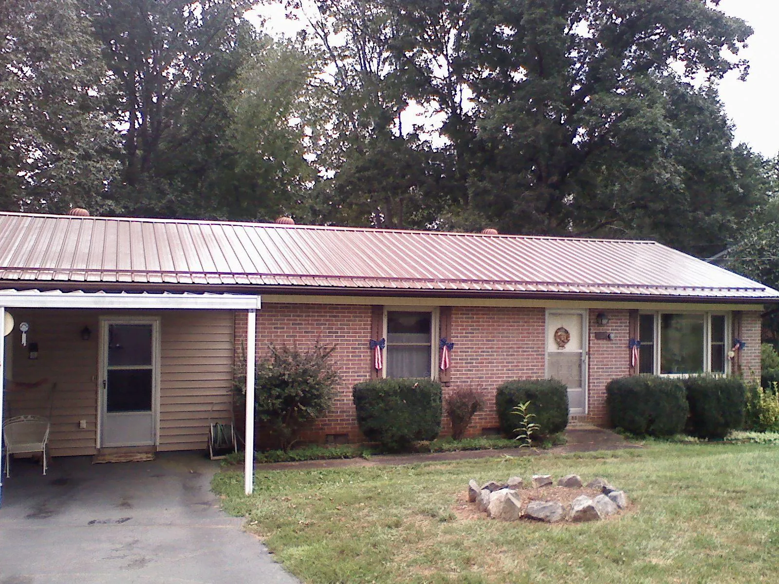 Bronze metal roof and carport on a brick ranch home — Roof Repair work by our crew in Richland